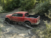 2021-ford-ranger-tremor-lariat-exterior-005-rear-three-quarters-driving-through-mud