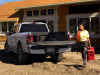 2022-ford-f-150-lightning-lariat-exterior-017-rear-three-quarters-tailgate-down-construction-site
