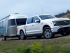 2022-ford-f-150-lightning-lariat-exterior-020-front-three-quarters-towing-trailer
