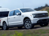 2022-ford-f-150-lightning-lariat-exterior-021-front-three-quarters-towing-trailer