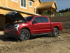 2022-ford-f-150-lightning-lariat-exterior-024-front-three-quarters-construction-site-frunk-open