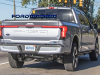 2022-ford-f-150-lightning-platinum-iconic-silver-first-on-the-road-photos-october-2021-exterior-012-rear-three-quarters-bed-tail-lights-light-bar-tailgate-f-150-debossed-logo-us-flag-ford-logo-badge