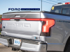 2022-ford-f-150-lightning-platinum-iconic-silver-first-on-the-road-photos-october-2021-exterior-013-tailgate-tail-lights-light-bar-f-150-debossed-logo-us-flag-ford-logo-badge-lightning-logo-badge