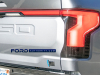 2022-ford-f-150-lightning-platinum-iconic-silver-first-on-the-road-photos-october-2021-exterior-014-tail-lights-light-bar-tailgate-us-flag-on-tailgate