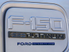 2022-ford-f-150-lightning-platinum-iconic-silver-first-on-the-road-photos-october-2021-exterior-021-charge-port-f-150-platinum-logo