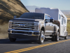 2023-ford-super-duty-f-350-drw-dually-lariat-press-photos-exterior-004-front-three-quarters-towing-trailer