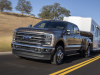 2023-ford-super-duty-f-350-drw-dually-lariat-press-photos-exterior-006-front-three-quarters-towing-trailer