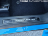 2021-ford-mustang-mach-e-first-edition-grabber-blue-fa-garage-interior-026-first-edition-logo-badge-front-sill