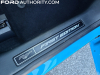 2021-ford-mustang-mach-e-first-edition-grabber-blue-fa-garage-interior-027-first-edition-logo-badge-front-sill