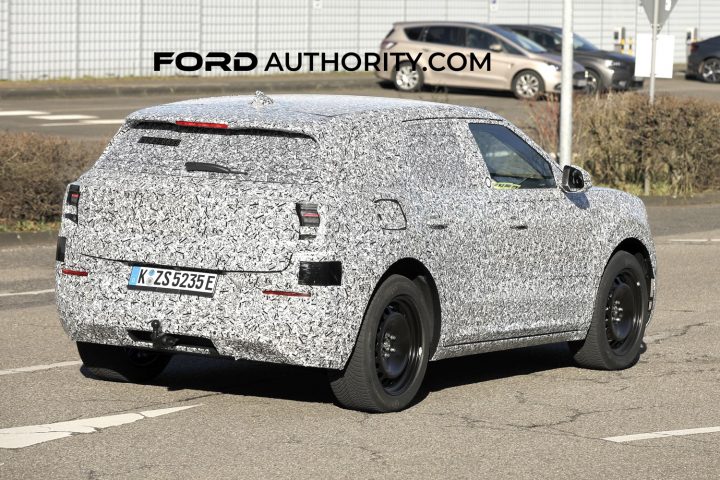 The upcoming Ford EV for Europe on public roads, wrapped in camo. Rear three quarter passenger side view