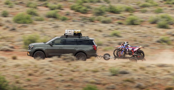 Side view of 2025 Ford Expedition Tremor towing a trailer of motorcycles.