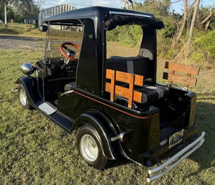 A photo showing the exterior of a 1930s style Ford golf cart from a rear three quarters angle.