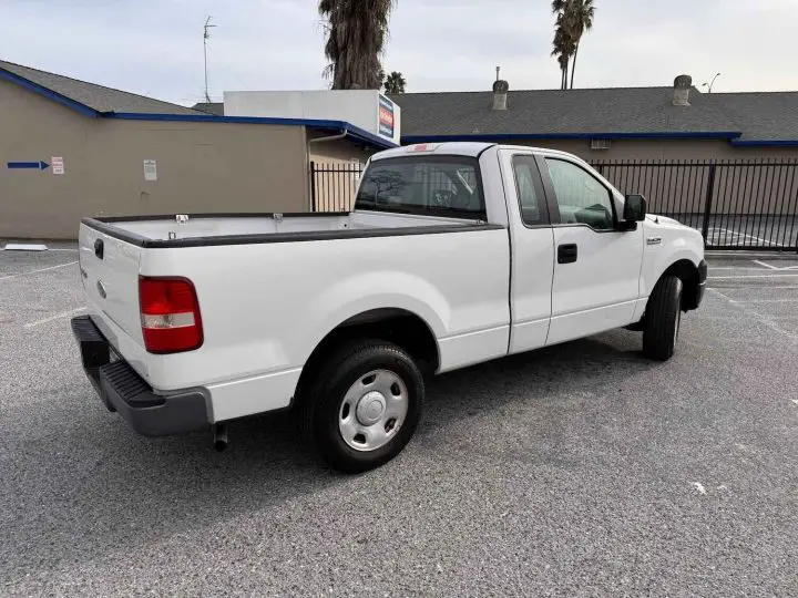 A photo showing the exterior of a 2005 Ford F-150 XL with 13k miles from a rear three quarters angle.