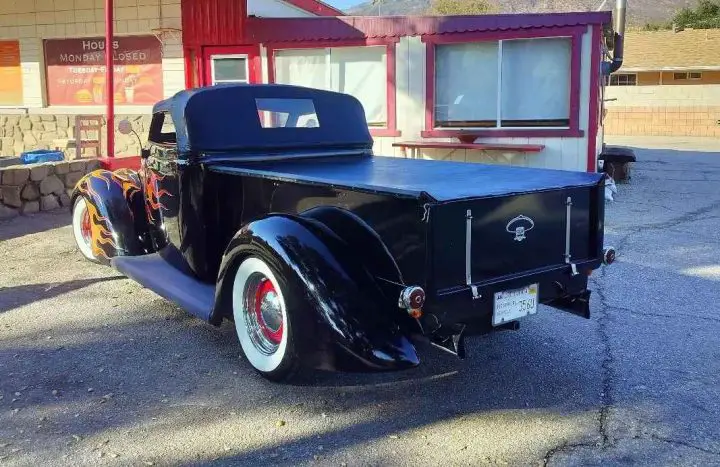A photo showing the exterior of a custom right-hand drive Ford pickup street rod from a rear three quarters angle.