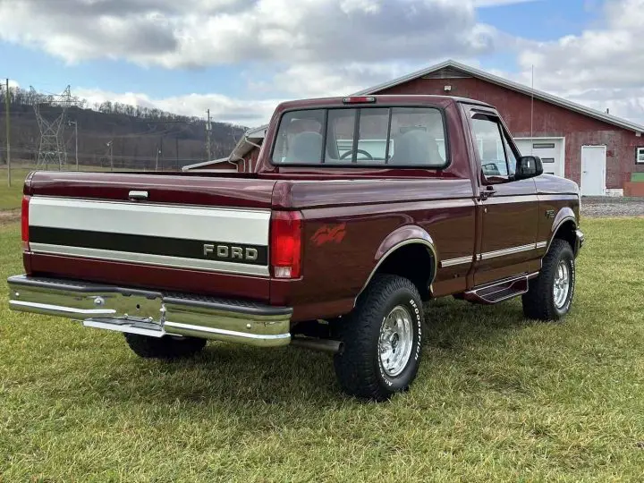 A photo showing the exterior of a 1996 Ford F-150 XLT with 5k miles from a rear three quarters angle.