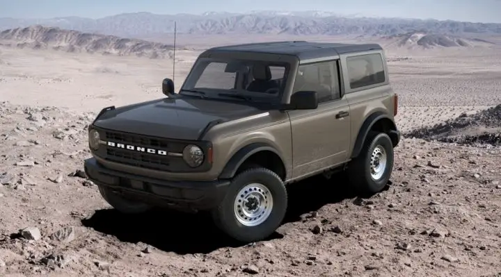 Photo of the 2025 Ford Bronco Base shown from a front three-quarters view. This model features the Black molded in color grille, one of eight available options across the lineup.