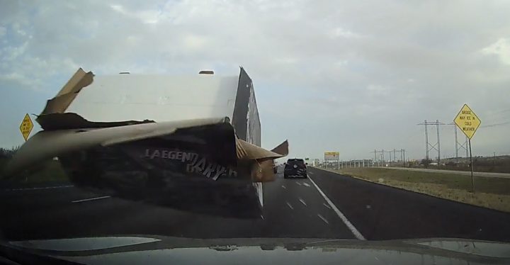 Video still of the box striking the cammer's windshield after flying out of the bed of a Ford Super Duty. The impact damaged the windshield enough to necessitate repairs. 