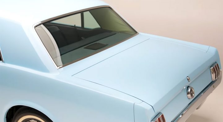 Video still of the 1964 1/2 Ford Mustang on display at the Petersen Museum, shown from a rear three-quarters angle. This model features the 289 cubic inch engine. 