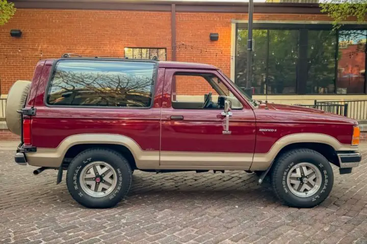 A side view of the 1989 Ford Bronco II for sale, showing just 9,000 miles on the odometer. 