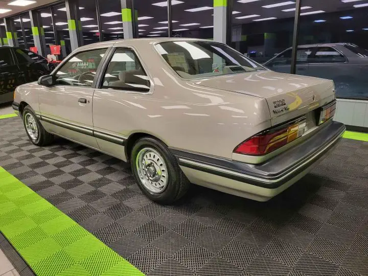 A photo showing the exterior of a 1990 Ford Taurus GL from a rear three quarters angle.