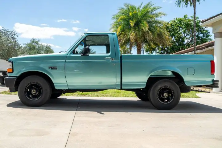 A side view of the 1995 Ford F-150 for sale, which has just 22,000 miles shown on its digital odometer.