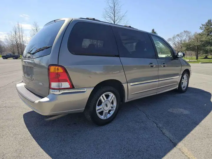 A photo showing the exterior of the 2002 Ford Windstar with 55k miles from a rear three quarters angle.
