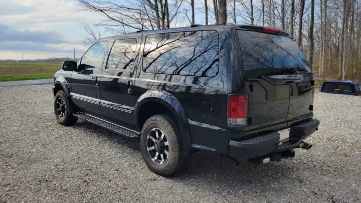 A photo showing the exterior of a 2003 Ford Excursion Executive Limo Conversion from a rear three quarters angle.