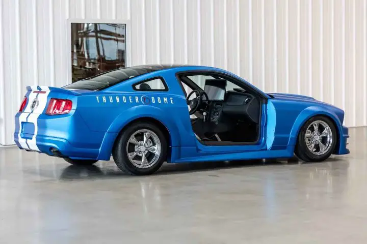 A photo showing the exterior of a 2010 Ford Mustang display car from a rear three quarters angle.