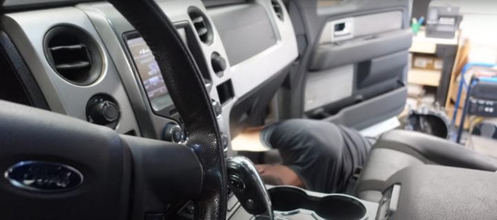 Video still of John Ross working on the 2013 Ford F-150 Raptor, which presented with a noisy blower motor after years of being caked with dirt. 