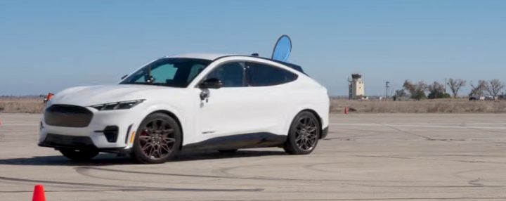 Video still of the Ford Mustang Mach-E GT on track, racing the Ford Mustang Dark Horse. The two models are actually fairly evenly matched.
