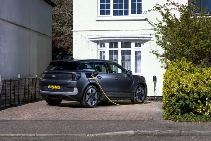 Photo of the Ford Explorer EV shown from a rear three-quarters angle, plugged in and charging in a homeowner's driveway. The Explorer EV weas the 19th most-registered BEV in Europe during March 2025.