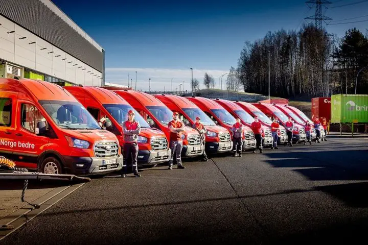 Photo showing a number of Ford E-Transit units that were purchased by the Norwegian Postal Service, all lined up in a row. The service has over 230 E-Transit vans already.