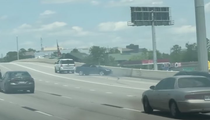 A photo of a Ford Expedition towing a Saab 9-3 convertible from a rear angle.