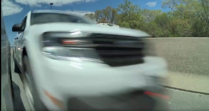 Video still of the Ford Maverick that illegally passed traffic on the shoulder and clipped the cam car's mirror. Their license plate is too blurry to be identified.