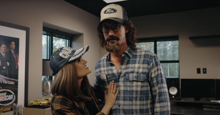 Video still of Brittany and Joey Logano dressed up in their disguises, ready to head out for a test drive in the Ford Bronco Raptor. The NASCAR driver did not let the salesman know who he really was. 