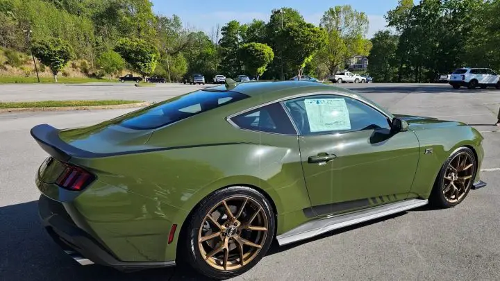 A photo showing the exterior of a NATO Olive 2025 Ford Mustang RTR Spec 3 from a rear three quarters angle.