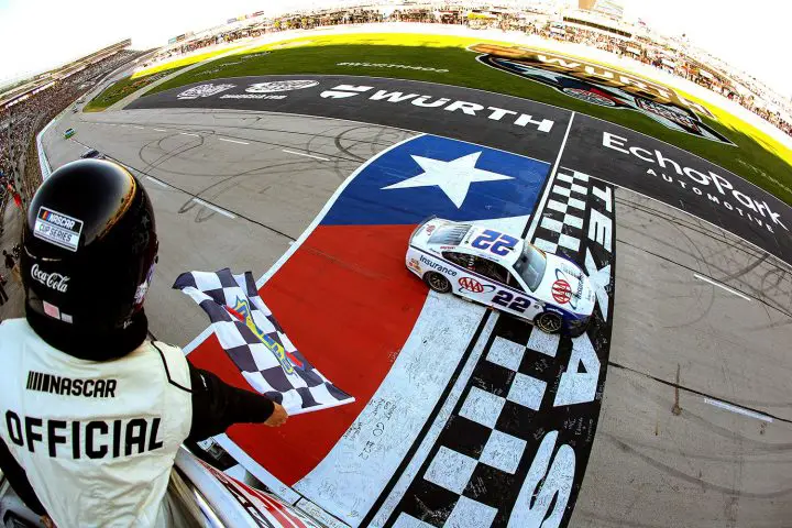 Photo of Joey Logano's No. 22 NASCAR Ford Mustang crossing the finish line at Texas in first. He was disqualified at Talladega just one week ago.