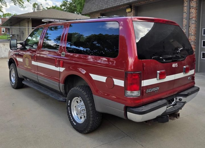 A photo showing the exterior of a 2001 Ford Excursion XLT fire rescue truck from a rear three quarters angle.