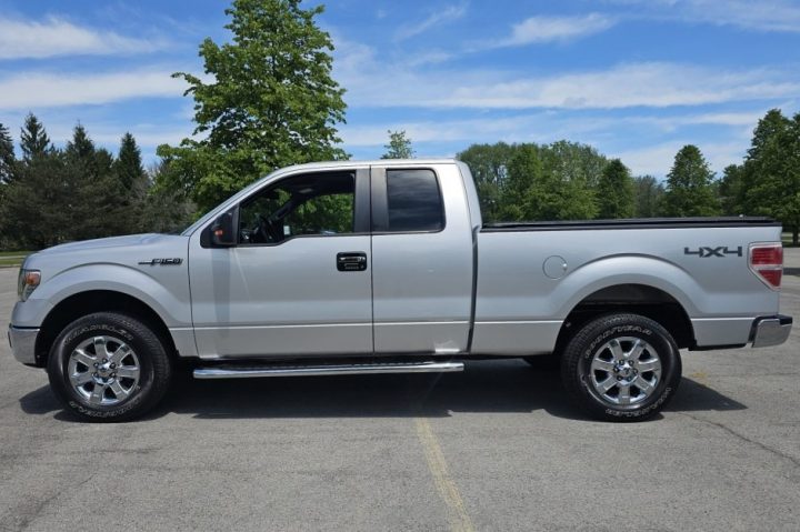 Photo showing the 2014 Ford F-150 XLT for sale from a side view. The pickup has just 11,000 original miles. 
