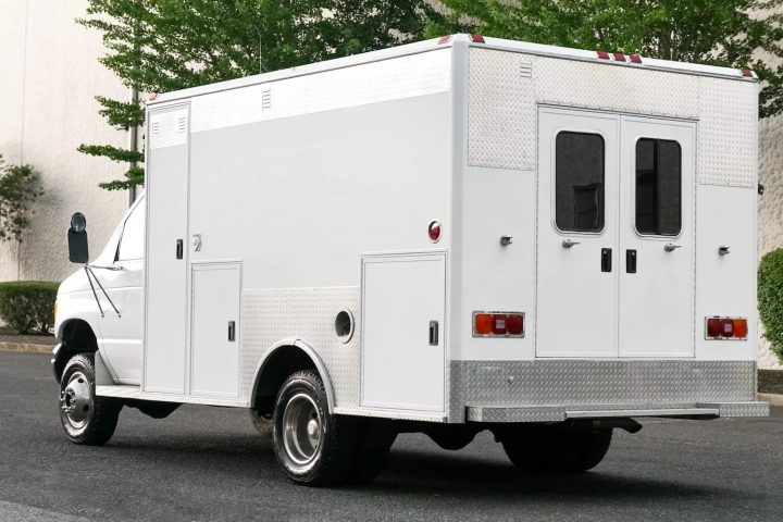 A photo showing the exterior of a 1995 Ford E-350 ambulance from a rear three quarters angle.