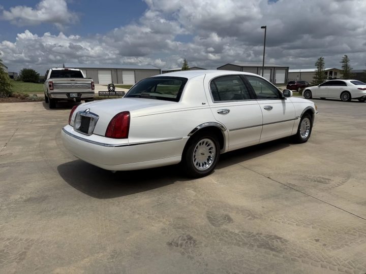 A photo showing the exterior of a 2002 Lincoln Town Car from a rear three quarters angle.