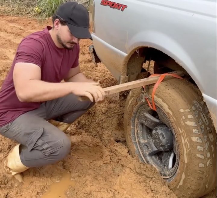 A photo showing the exterior of a Ford Ranger stuck in the mud from a bedside angle.