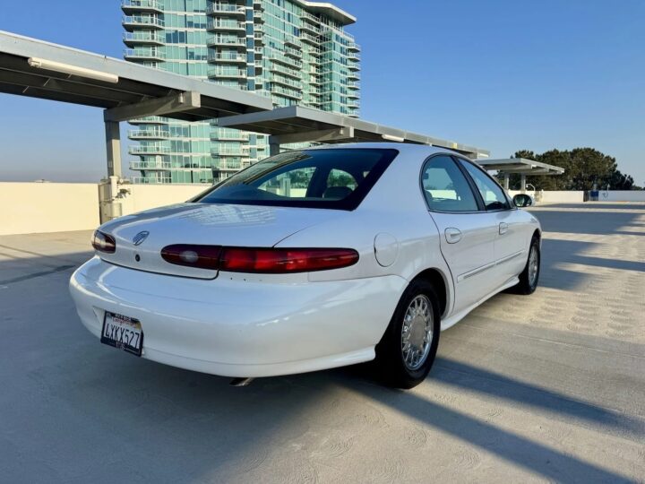 A photo showing the exterior of a 1996 Mercury Sable LS sedan from a rear three quarters angle.