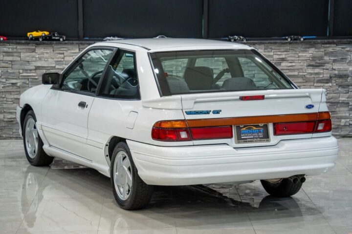 A photo showing the exterior of a 1992 Ford Escort GT from a rear three quarters angle.
