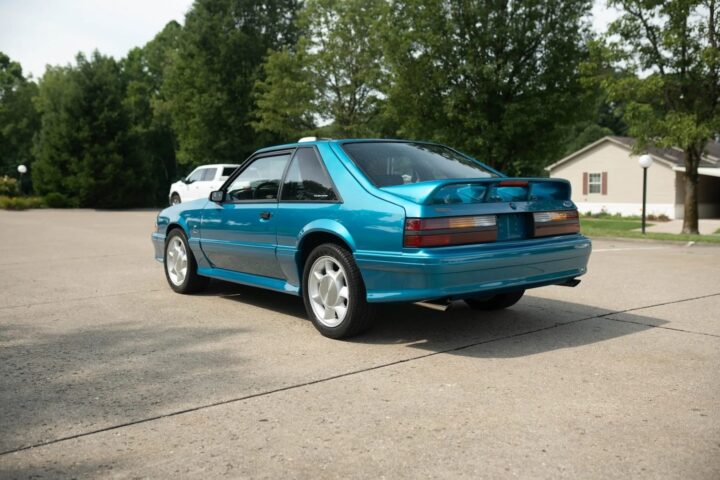 A photo showing the exterior of a 1993 Ford Mustang SVT Cobra from a rear three quarters angle.