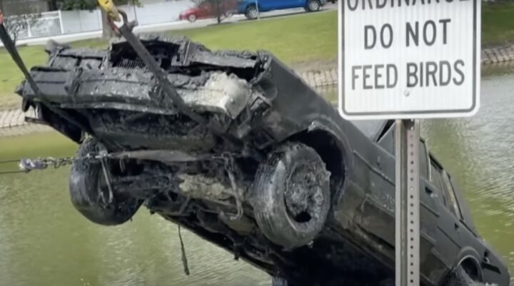 A photo showing a Lincoln Town Car being pulled from a retention pond.