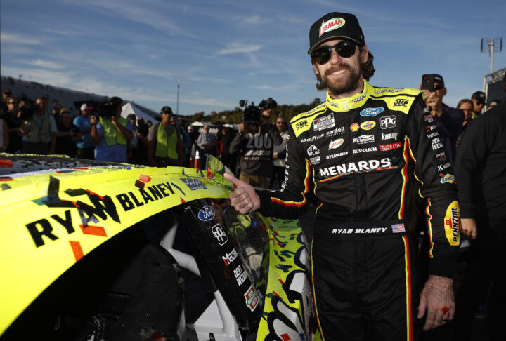 Photo of Ryan Blaney posing next to his NASCAR Ford race car after winning at New Hampshire in September 2025. He could very well win a second championship. 