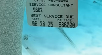 Video still showing the 2011 Ford Escape Hybrid oil change sticker, revealing 586K miles racked up over its life.