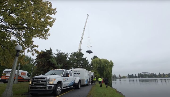 A photo showing the exterior of a Ford Expedition being pulled from a lake from a front three quarters angle.