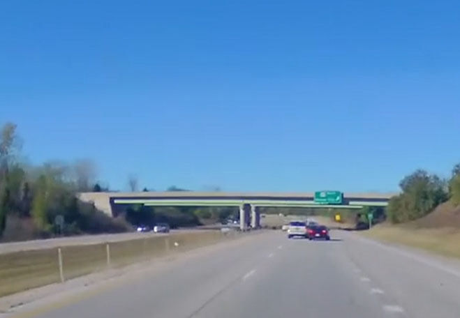 Video still of the white Ford Expedition swerving at the Dodge Challenger for seemingly no reason.